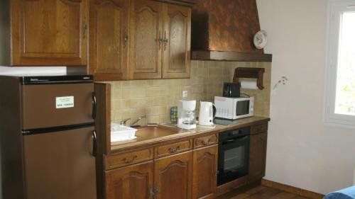 a kitchen with wooden cabinets and a sink and a refrigerator at super T2 in Blanquefort