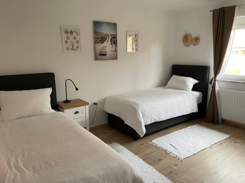 a bedroom with two beds and a window at Apartma Luka in Ptuj