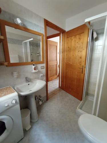 bagno con lavandino, servizi igienici e specchio di THE LITTLE NEST a Valdisotto