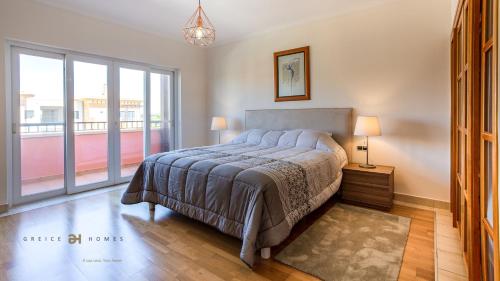 - une chambre avec un lit et une grande fenêtre dans l'établissement Greice Homes-2 bedroom penthouse Vilamoura, à Quarteira