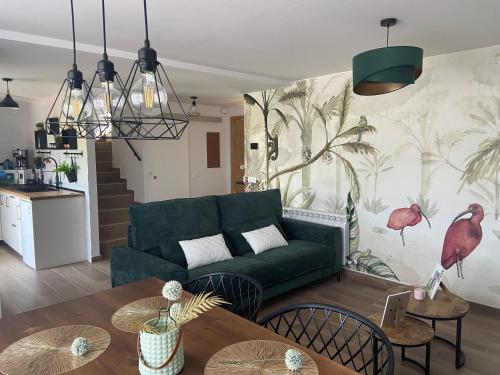 a living room with a green couch and a table at Las Casas de Lola in Candeleda