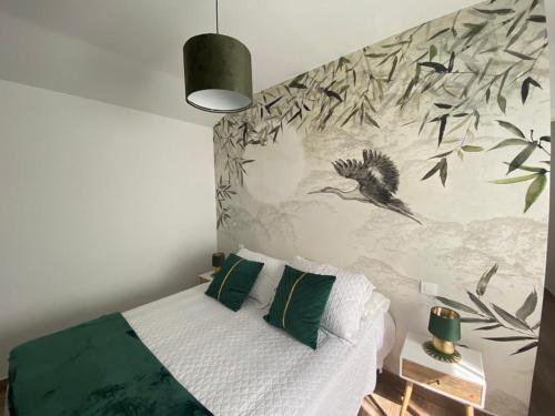 a bedroom with a bed with a bird mural on the wall at Las Casas de Lola in Candeleda