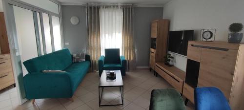 uma sala de estar com um sofá azul e uma televisão em Apartment Franko em Pula
