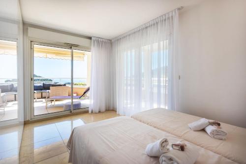 - une chambre blanche avec 2 lits et un balcon dans l'établissement EZE VISTA AP4328 By Riviera Holiday Homes, à Èze