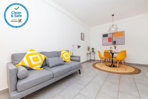 a living room with a gray couch and a table at Vasco Da Gama Apartments in Lagos