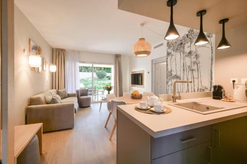 eine Küche mit einem Waschbecken und ein Wohnzimmer in der Unterkunft Chant des Vagues Saint Tropez VIII in Saint-Tropez