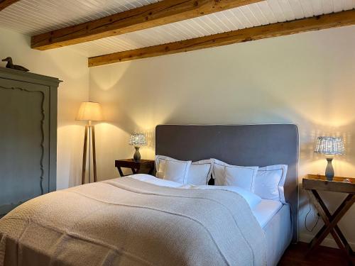 a bedroom with a large white bed with two lamps at Stimbekhof in Bispingen