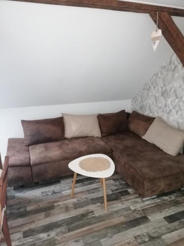 a living room with a brown couch and a table at Ferienwohnung IV Sarrebriese in Bottmersdorf