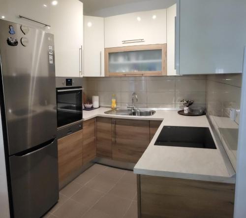 a kitchen with a stainless steel refrigerator and a sink at Apartman Pati in Livno