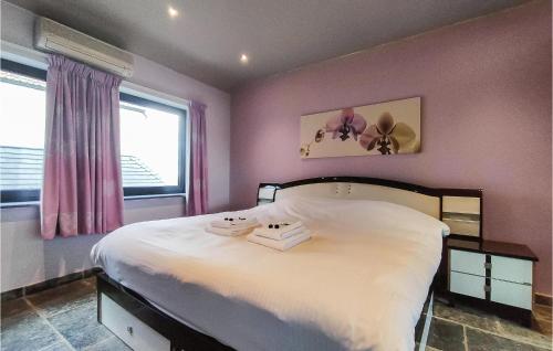 a bedroom with a large white bed with pink walls at Nice Home In Damme With Wifi in Damme