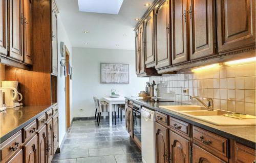 a kitchen with wooden cabinets and a sink and a table at Nice Home In Damme With Wifi in Damme