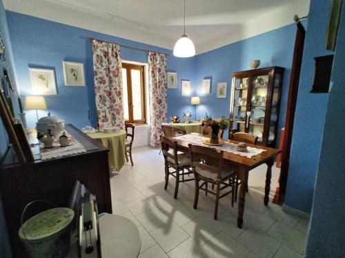 une salle à manger avec des murs bleus, une table et des chaises dans l'établissement afra Bed & Breakfast, à Castellabate