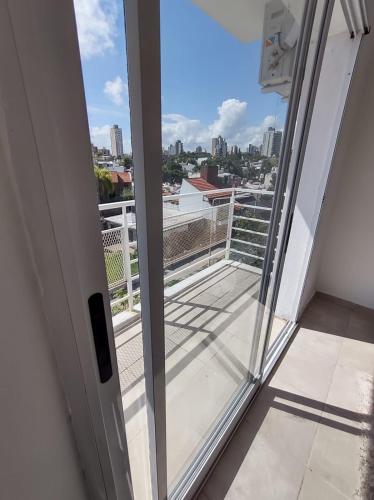 een deur naar een balkon met uitzicht op de stad bij Departamento PARQUE in Paraná