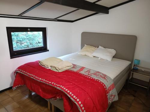 Un dormitorio con una cama con una manta roja. en Maison Sunpark Oostduinkerk 550 en Koksijde