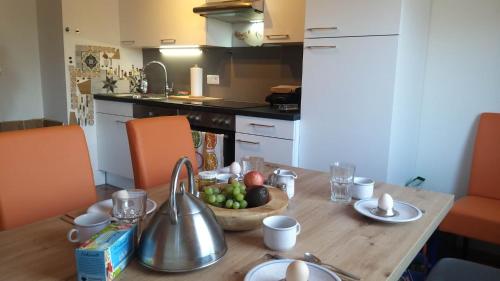 Appartement Rose في لييزين: مطبخ مع طاولة خشبية مع وعاء من الفواكه