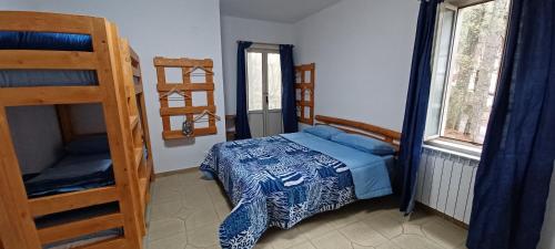 La Casa di Chicca في كاميغلياتيلو سيلانو: غرفة نوم مع سرير وسريرين بطابقين
