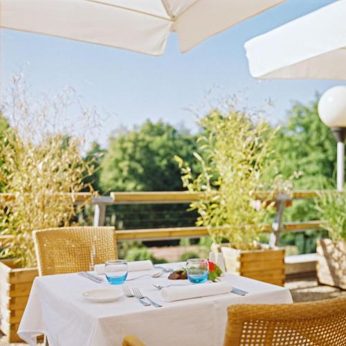 a table with a white table cloth on a patio at La Clairière bio & spahotel in La Petite-Pierre