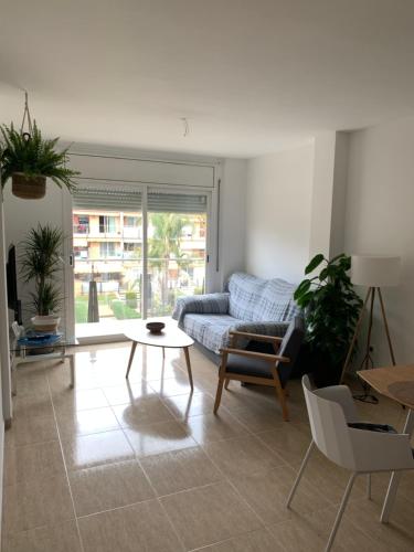 uma sala de estar com um sofá e uma mesa em Acogedor apartamento con piscina en Vilafortuny, Cambrils em Cambrils