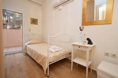 Schlafzimmer mit einem Bett, einem Tisch und einem Spiegel in der Unterkunft Aelia luxury apartment with private entrance in Karavomylos