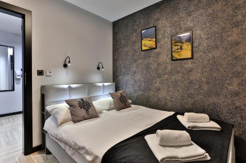 a bedroom with a large bed with two pillows on it at Apartament 33 Lake & View Centralny Widok na Jezioro -100 metrów od Jeziora Czorsztyńskiego i ścieżki rowerowej Velo Czorsztyn in Kluszkowce