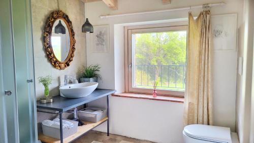 un bagno con lavandino, specchio e finestra di Agriturismo Podere Le Palaie a Monterotondo