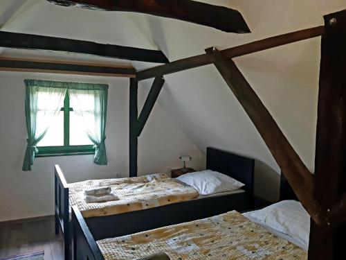 two beds in a room with a cross window at Bakina iža in Duga Resa