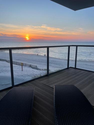 a deck with a view of the beach at sunset at Floryda Gardenia Seaside in Dziwnów