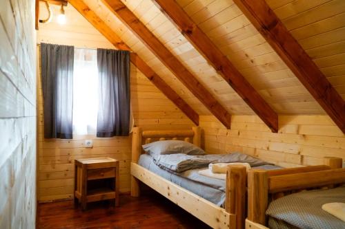 una camera con un letto in una baita di tronchi di FOREST&LAKE COTTAGES a Virpazar