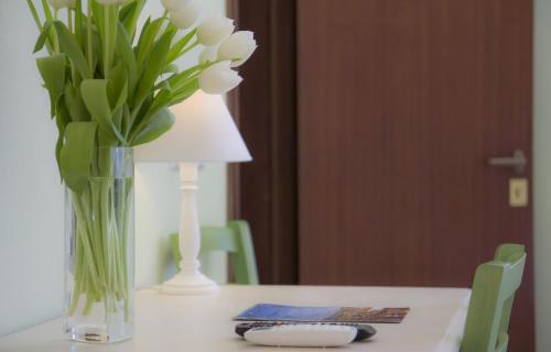 a vase of white flowers and a lamp on a table at Il Linchetto in Lucca