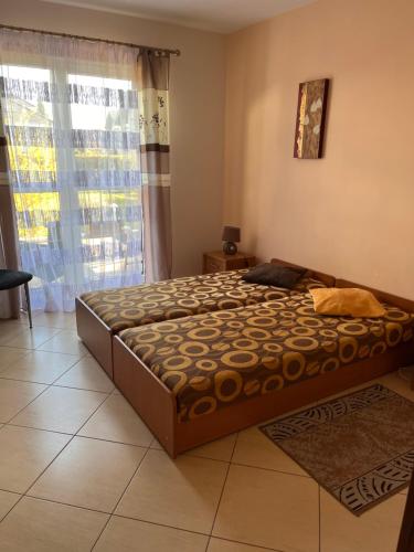 a bed in a room with a large window at Bungalow am Meer in Grzybowo