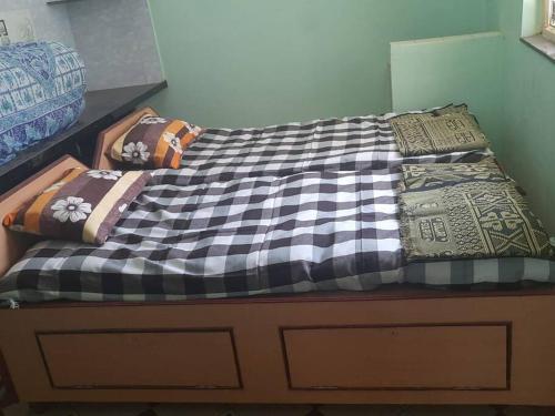 uma cama com várias almofadas em cima em Bhaktikunj Detached 2 room House em Akalkot
