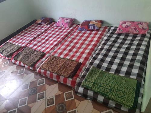 uma cama com quatro almofadas em cima em Bhaktikunj Detached 2 room House em Akalkot