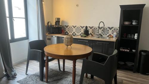 普瓦捷的住宿－B - Le petit Paradis，厨房配有桌椅和水槽。
