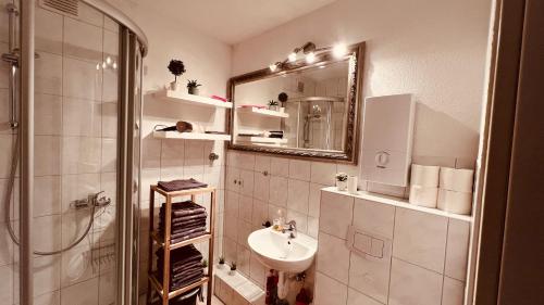 a bathroom with a sink and a shower and a mirror at Messewohnung Düsseldorf/Essen in Ratingen