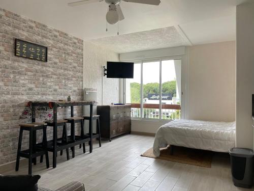une chambre avec un lit, une table et une fenêtre dans l'établissement Studio centre-ville a quelque pas de la plage - WIFI, à La Grande Motte