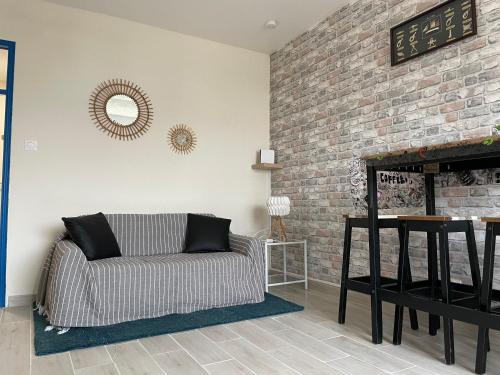 - un salon avec un canapé et une cheminée en briques dans l'établissement Studio centre-ville a quelque pas de la plage - WIFI, à La Grande Motte
