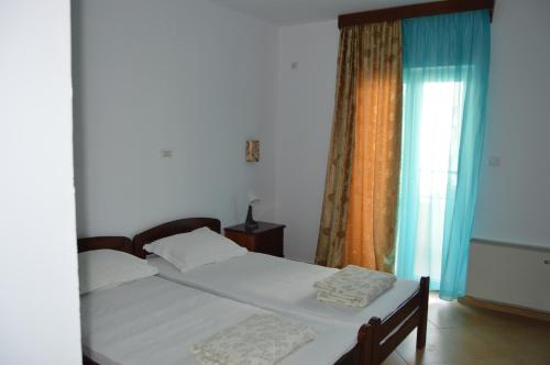 a bedroom with a bed and a window at Vila Maslina Guesthouse in Budva