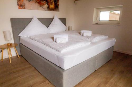 a large white bed in a room with a window at Servus Apartments Neuhaus am Inn in Neuhaus am Inn