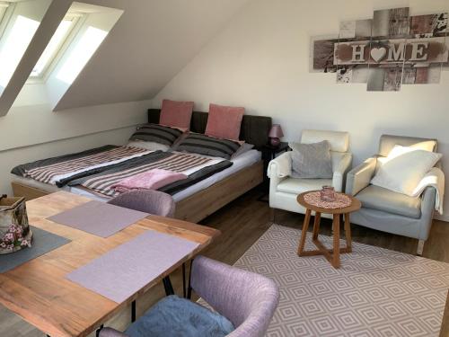 una stanza con un letto, un tavolo e delle sedie di Ferienland Sonnenwald Fewo 46 und Studio 50 in Schöfweg Bayerischer Wald a Schöfweg