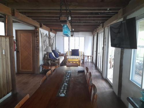 sala de estar con mesa larga con sillas y TV de pantalla plana en Casa, Cabo Tortugas, Monterrico, en Monterrico