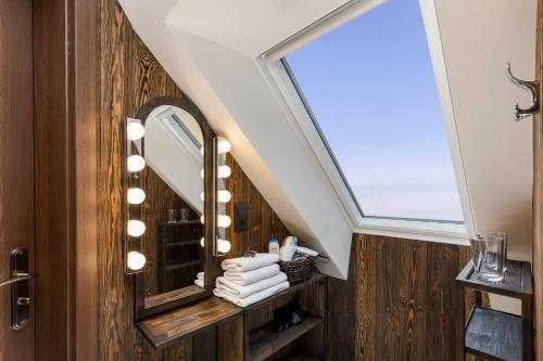 a bathroom with a mirror and a skylight at Apartament Podskalański in Szyce