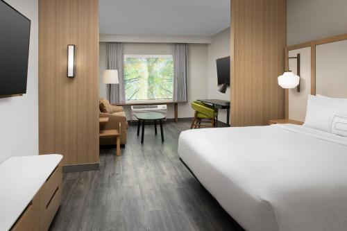 ゲインズビルにあるFairfield Inn & Suites by Marriott Gainesville I-75の大きなベッドとデスクが備わるホテルルームです。