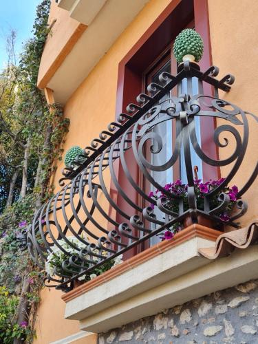 a balcony with potted plants on a window at B&B RE TANCREDI in Taormina