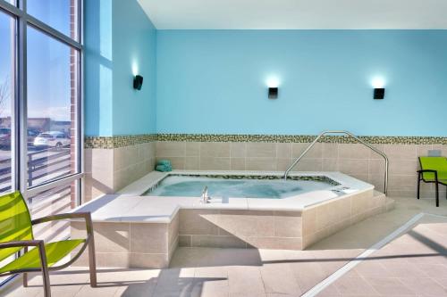 uma banheira de hidromassagem num quarto com janela em SpringHill Suites by Marriott Salt Lake City Sugar House em Salt Lake City