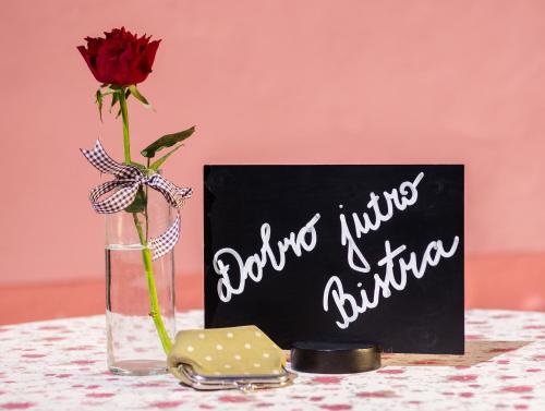 a vase with a flower and a sign that says anytime hugs a girlfriend at Guesthouse Bistra in Vrhnika