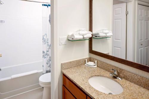 a bathroom with a sink and a toilet and a mirror at Residence Inn Cherry Hill Philadelphia in Cherry Hill