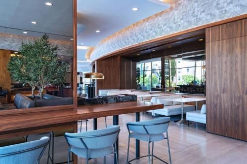 a restaurant with wooden walls and blue chairs at AC Hotel by Marriott Monterrey Valle in Monterrey