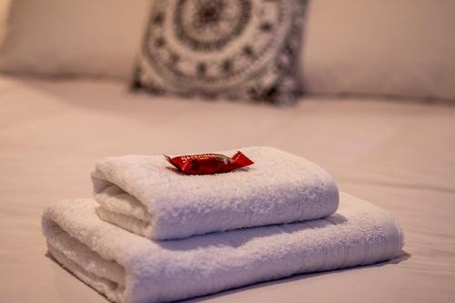 een stapel handdoeken bovenop een bed bij Andromeda apartments in Spáta