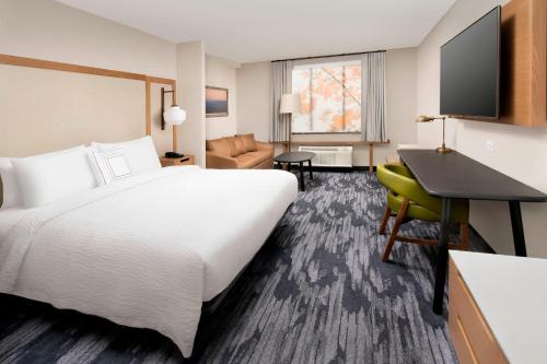 a hotel room with a large bed and a desk at Fairfield Inn & Suites by Marriott Alexandria West/Mark Center in Alexandria