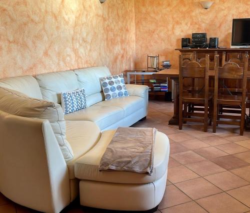 Spicchio di Langa - casa indipendente tra le vigne e le Alpi في Belvedere Langhe: غرفة معيشة مع أريكة وطاولة